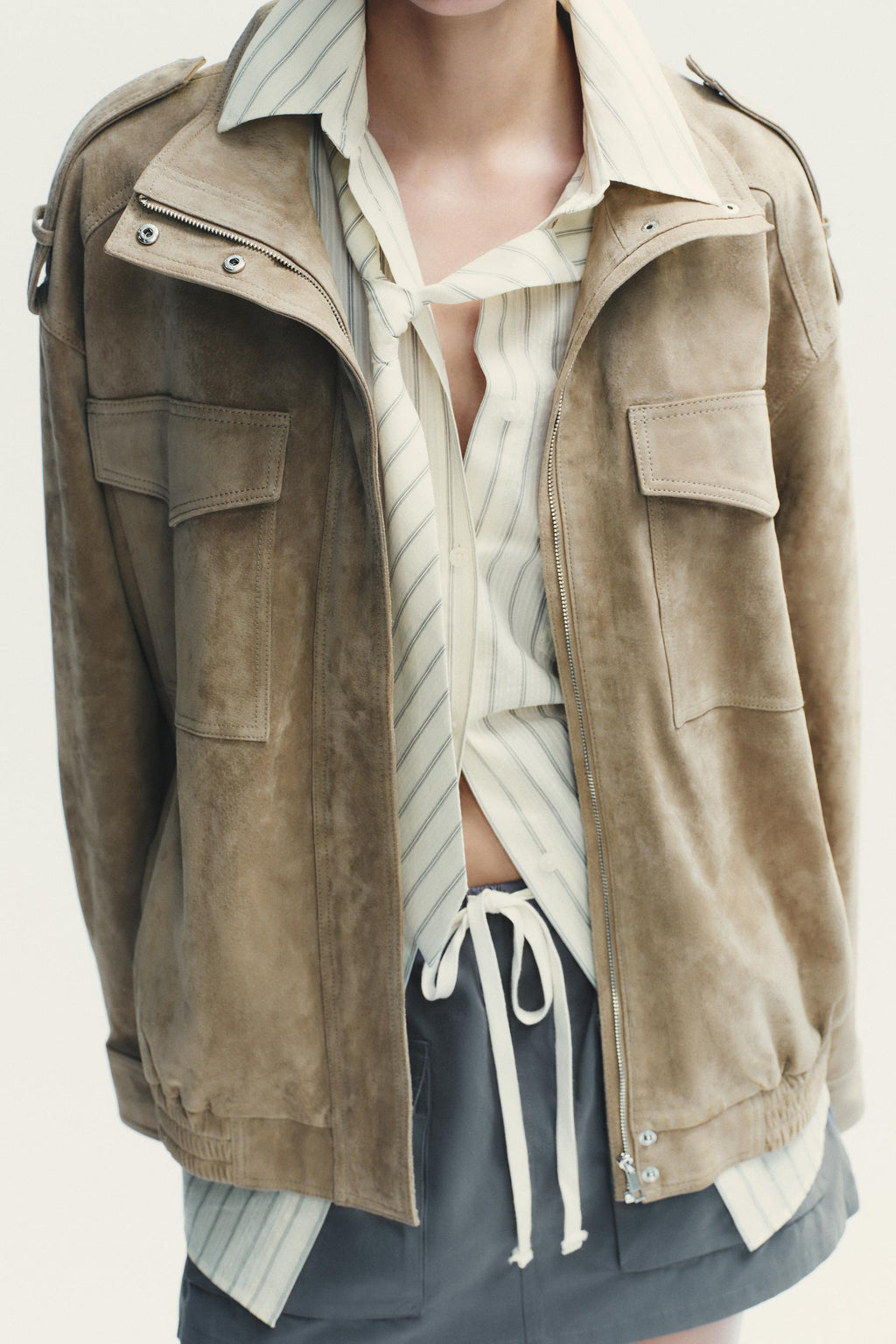 Elevate your style with this Suede Leather Jacket, featuring a high collar for added warmth and sophistication. The long cuffed sleeves with shoulder tabs add a touch of rugged elegance, while front and chest flap pockets combine functionality with fashion. The zip-up front is secured with a snap-button placket, ensuring both convenience and a sleek finish. Perfect for layering, this jacket offers a timeless look that effortlessly enhances any outfit.