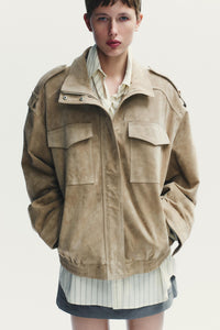 Elevate your style with this Suede Leather Jacket, featuring a high collar for added warmth and sophistication. The long cuffed sleeves with shoulder tabs add a touch of rugged elegance, while front and chest flap pockets combine functionality with fashion. The zip-up front is secured with a snap-button placket, ensuring both convenience and a sleek finish. Perfect for layering, this jacket offers a timeless look that effortlessly enhances any outfit.