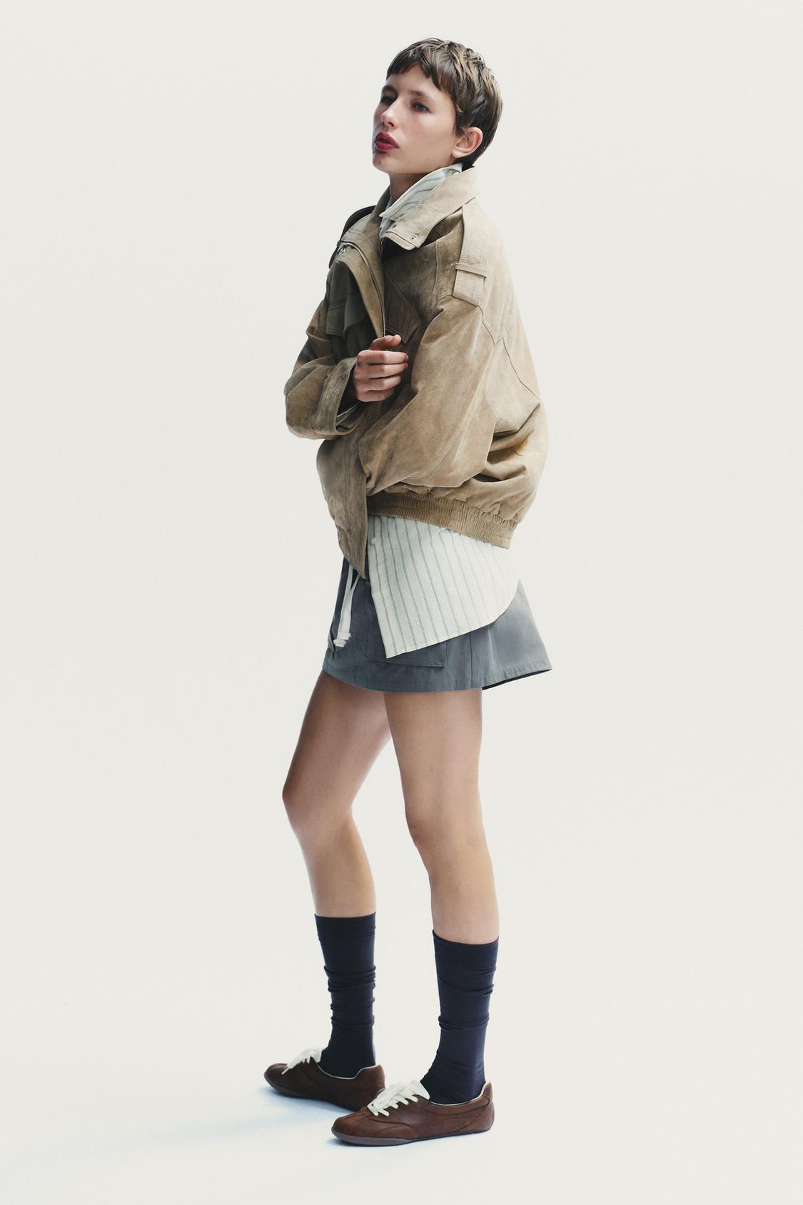 Elevate your style with this Suede Leather Jacket, featuring a high collar for added warmth and sophistication. The long cuffed sleeves with shoulder tabs add a touch of rugged elegance, while front and chest flap pockets combine functionality with fashion. The zip-up front is secured with a snap-button placket, ensuring both convenience and a sleek finish. Perfect for layering, this jacket offers a timeless look that effortlessly enhances any outfit.