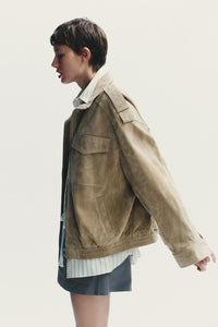 Elevate your style with this Suede Leather Jacket, featuring a high collar for added warmth and sophistication. The long cuffed sleeves with shoulder tabs add a touch of rugged elegance, while front and chest flap pockets combine functionality with fashion. The zip-up front is secured with a snap-button placket, ensuring both convenience and a sleek finish. Perfect for layering, this jacket offers a timeless look that effortlessly enhances any outfit.