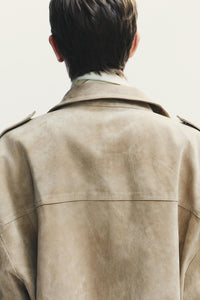 Elevate your style with this Suede Leather Jacket, featuring a high collar for added warmth and sophistication. The long cuffed sleeves with shoulder tabs add a touch of rugged elegance, while front and chest flap pockets combine functionality with fashion. The zip-up front is secured with a snap-button placket, ensuring both convenience and a sleek finish. Perfect for layering, this jacket offers a timeless look that effortlessly enhances any outfit.