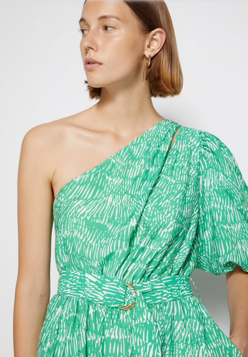 Elevate your beach look with the Mini Dress Adrianna in Kelly Abstract Fern. This breezy swimwear coverup dress features a one-shoulder design and short puffed sleeves for a touch of trendy elegance. Perfect for transitioning from poolside to a summer party.