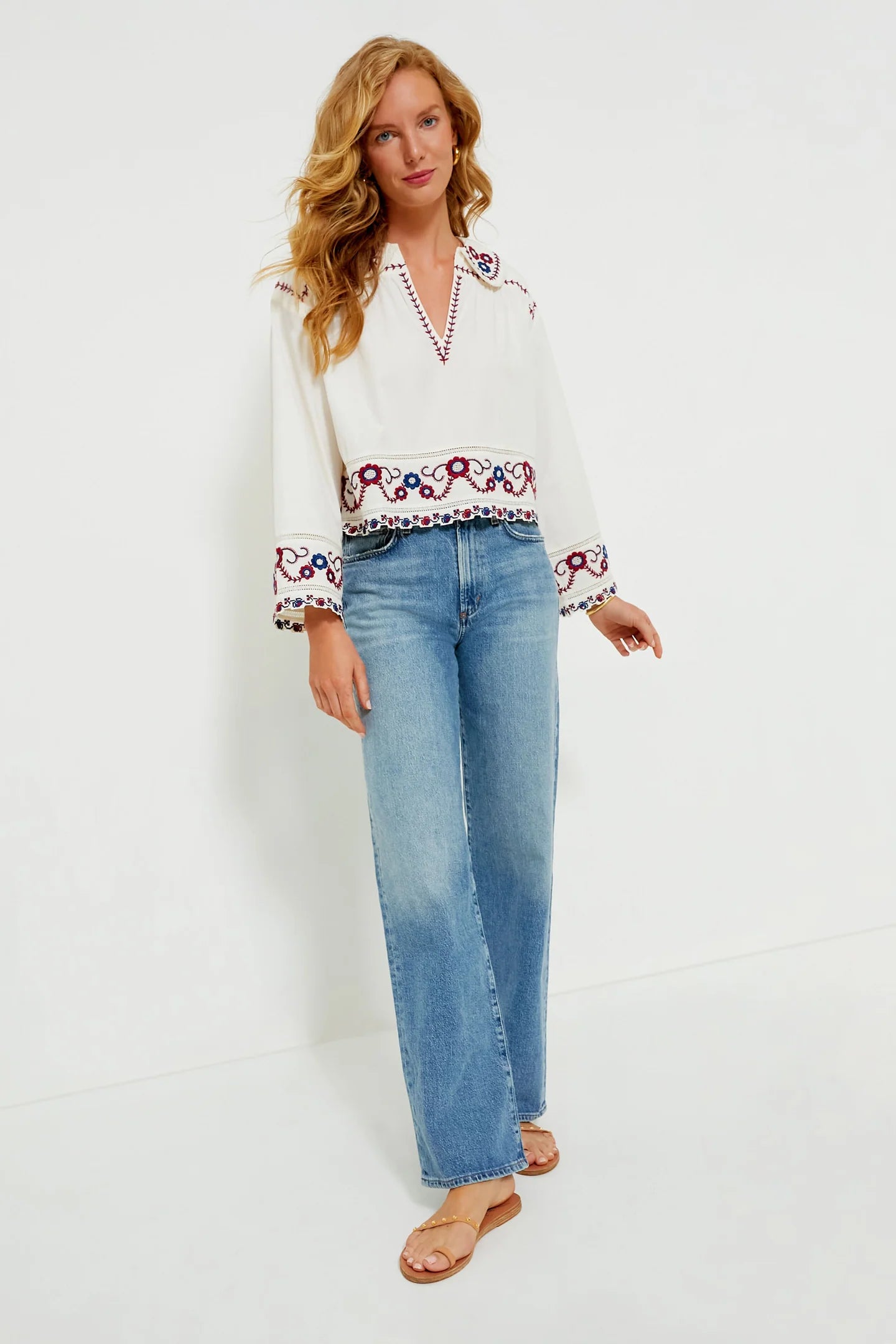 The Soren Embroidery Long Sleeve Top from Sea New York combines effortless style with sophisticated details. Crafted from soft cotton, this blouse features a collared V-neckline and long bell sleeves with subtle shoulder pleats for a refined silhouette. Elegant contrast embroidery adorns the hem and cuffs, adding a delicate, feminine touch. Versatile and modern, it pairs seamlessly with denim and flats for an easy yet polished look that channels boho-chic cool with understated elegance.