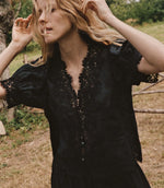 Load image into Gallery viewer, Crafted from lightweight, crisp ramie, the Idella Top from Doen features a plunging V-neckline, short puffed sleeves, and intricate embroidered lace details. Mother-of-pearl buttons adorn the front, while lace insets add delicate touches. This antique-inspired top is perfect for a breezy, feminine look.
