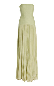 The Sunniva Plisse Strapless Gown showcases a fitted strapless bodice with a gracefully curved dropped waist, leading into a flowing plisse skirt that moves elegantly with every step. Its timeless silhouette emphasizes a refined, feminine shape, perfect for occasions that call for understated sophistication. Pair with statement earrings to elevate the look, capturing the essence of modern elegance.