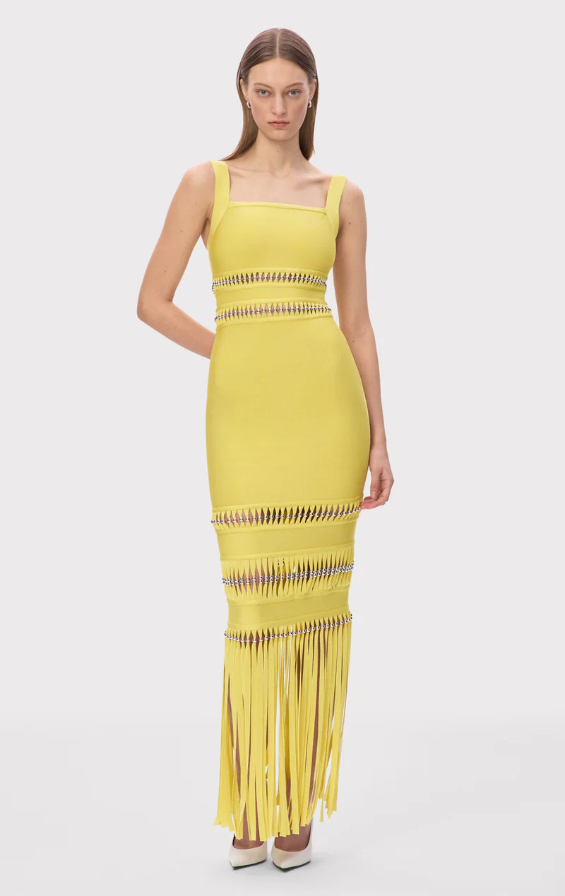 The Ines Gown by Herve Leger is a masterpiece of contemporary sophistication. Its body-contouring midi silhouette flatters every curve, while the striking square neckline commands attention. Hand-placed silver beads catch the light beautifully, creating an enchanting shimmer that draws the eye. Strategic cutouts offer tasteful glimpses of skin, adding an element of allure without compromising elegance. 