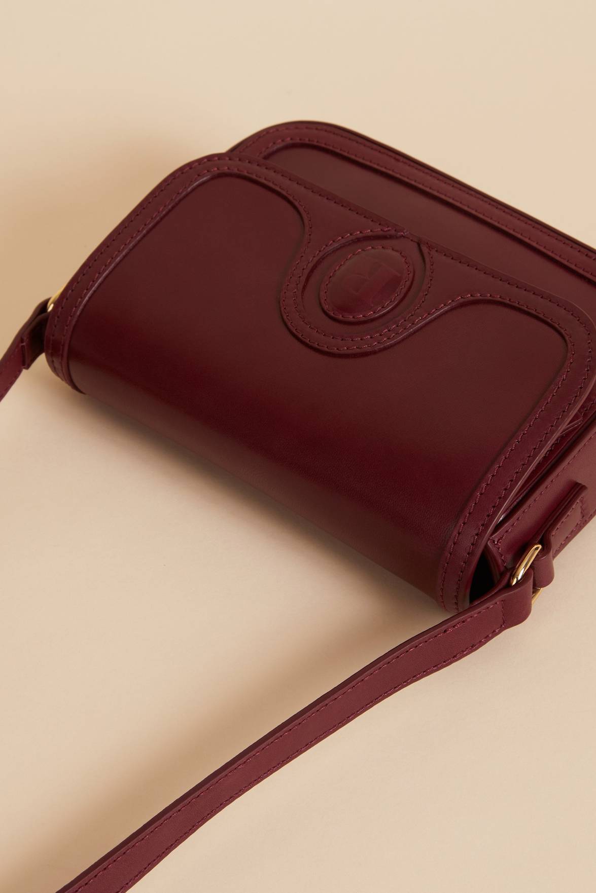 The Sac a main Bibi Nappa is the perfect accessory for any outfit. Made from 100% smooth cow leather, this small bag features a stylish "R" embossed flap with a magnetic closure. With its sleek design and bold burgundy color, it's both functional and fashionable.