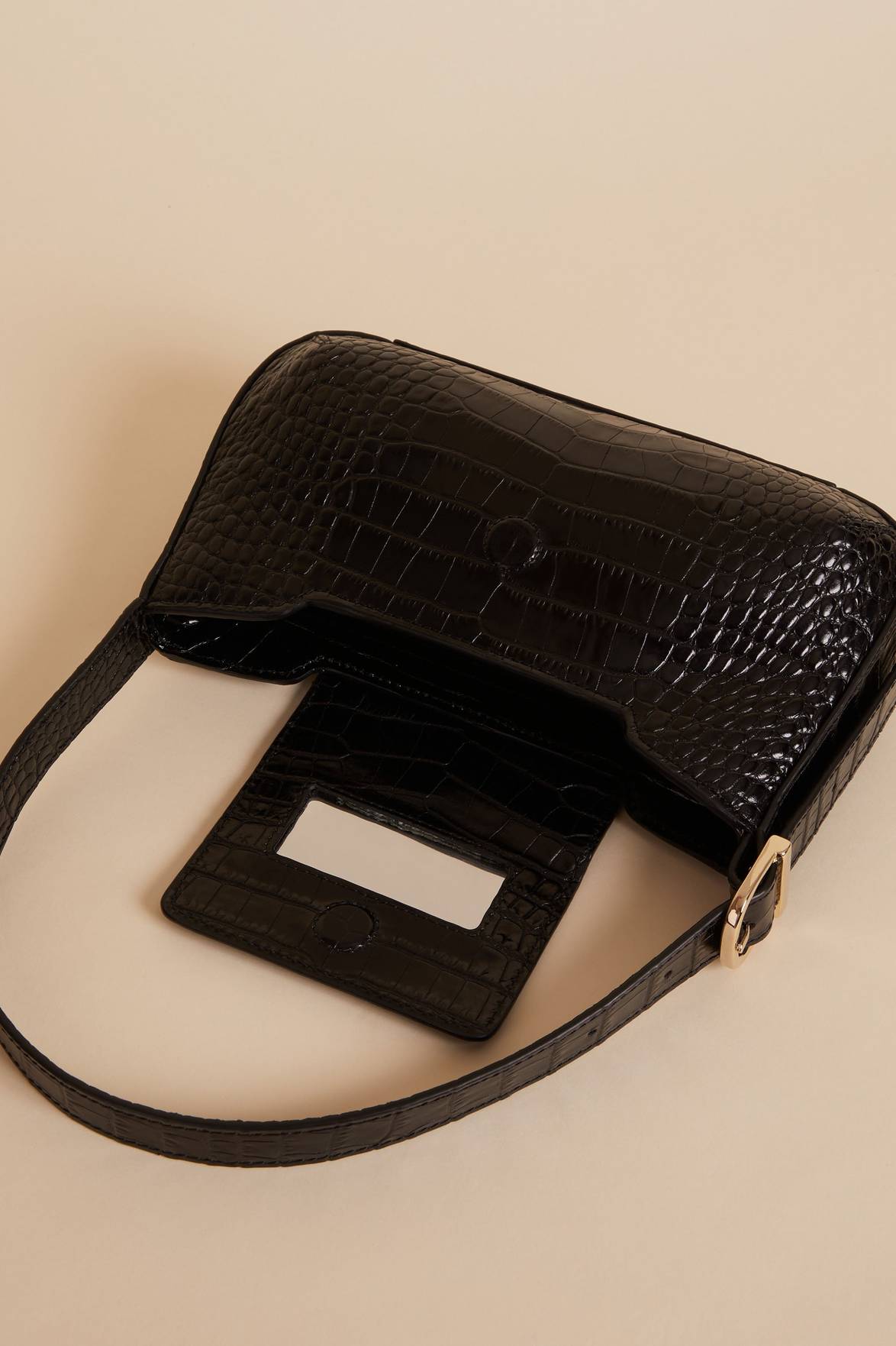 Upgrade your accessory game with the Baguette Bag. The striking crocodile-style design, small handle, magnetic flap, and secure closure make this Bag in black a statement piece. Elevate your look and carry your essentials in style.