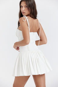 Add some summer fun to your wardrobe with "Marcy"! This mini A-line dress features a playful pleated skirt and a ruched bodice, making it perfect for birthday parties, vacations, and nights out. Its zippered back and full lining ensure comfort, while the "Lola" white heels add a touch of elegance. Cheers to sunny days!