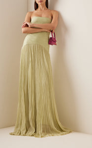 The Sunniva Plisse Strapless Gown showcases a fitted strapless bodice with a gracefully curved dropped waist, leading into a flowing plisse skirt that moves elegantly with every step. Its timeless silhouette emphasizes a refined, feminine shape, perfect for occasions that call for understated sophistication. Pair with statement earrings to elevate the look, capturing the essence of modern elegance.