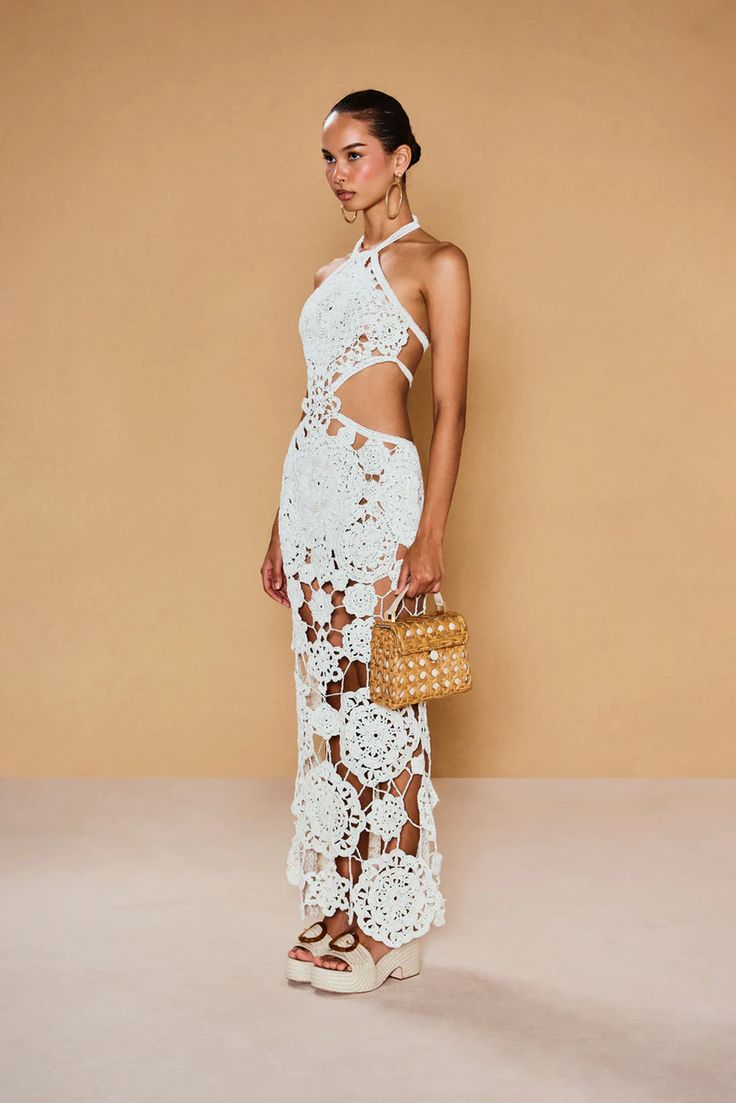 Be a true vision in the Accalia Crochet Gown by Cult Gaia. This masterpiece features hand-crocheted geometric and floral patterns, cutouts at the waist, and a halter neckline for an elegant and alluring look. The open back and adjustable neck tie allow for a perfect fit. Turn heads in this ankle-length gown!