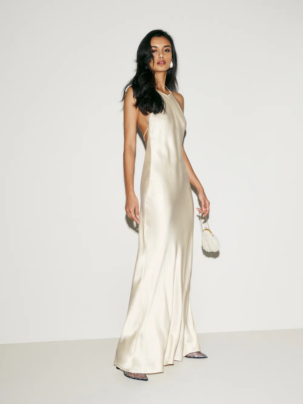 The Jeany Silk Dress by Reformation features adjustable straps and a flattering halter neckline, with elegant back buttons and bias stitching that enhances its fluid silhouette. Designed to graze the floor when paired with heels, this dress offers a graceful, elongated look—hemming may be needed to perfectly suit your height. Ties in the back provide a customizable fit, making it both stunning and comfortable for any special occasion.