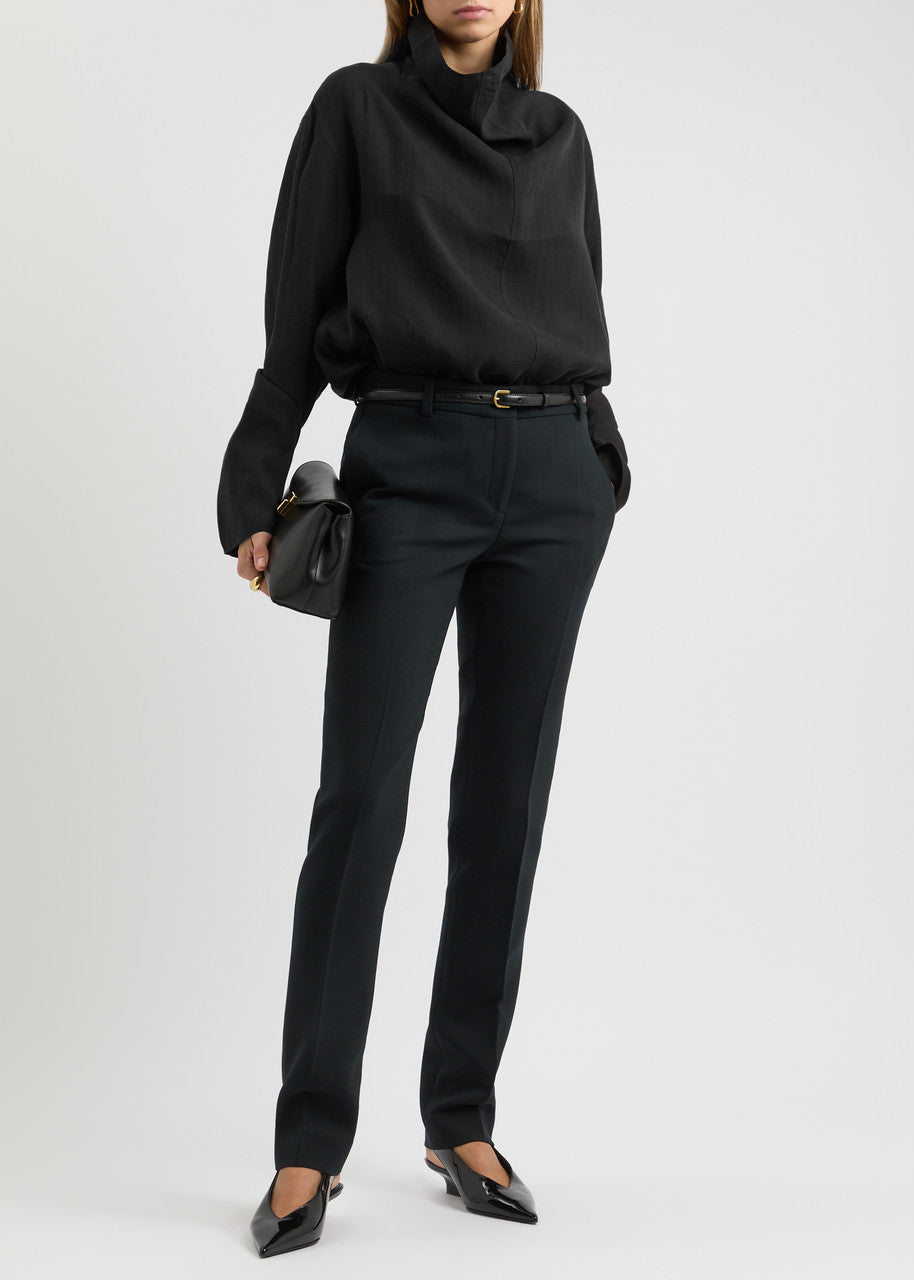 Elevate your wardrobe with this draped woven blouse by Toteme featuring a sophisticated funnel neck and relaxed dropped shoulders for effortless style. The curved hem with a longer back adds a contemporary silhouette, while the detachable cami lining offers versatility and comfort. Perfect for both casual and polished looks, this blouse combines elegance with adaptable wearability.