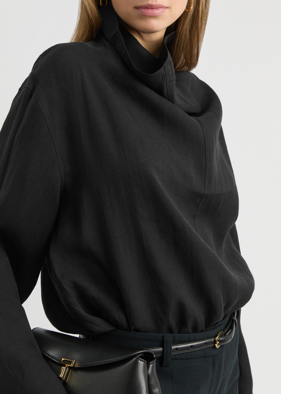 Elevate your wardrobe with this draped woven blouse by Toteme featuring a sophisticated funnel neck and relaxed dropped shoulders for effortless style. The curved hem with a longer back adds a contemporary silhouette, while the detachable cami lining offers versatility and comfort. Perfect for both casual and polished looks, this blouse combines elegance with adaptable wearability.