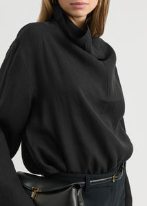 Elevate your wardrobe with this draped woven blouse by Toteme featuring a sophisticated funnel neck and relaxed dropped shoulders for effortless style. The curved hem with a longer back adds a contemporary silhouette, while the detachable cami lining offers versatility and comfort. Perfect for both casual and polished looks, this blouse combines elegance with adaptable wearability.