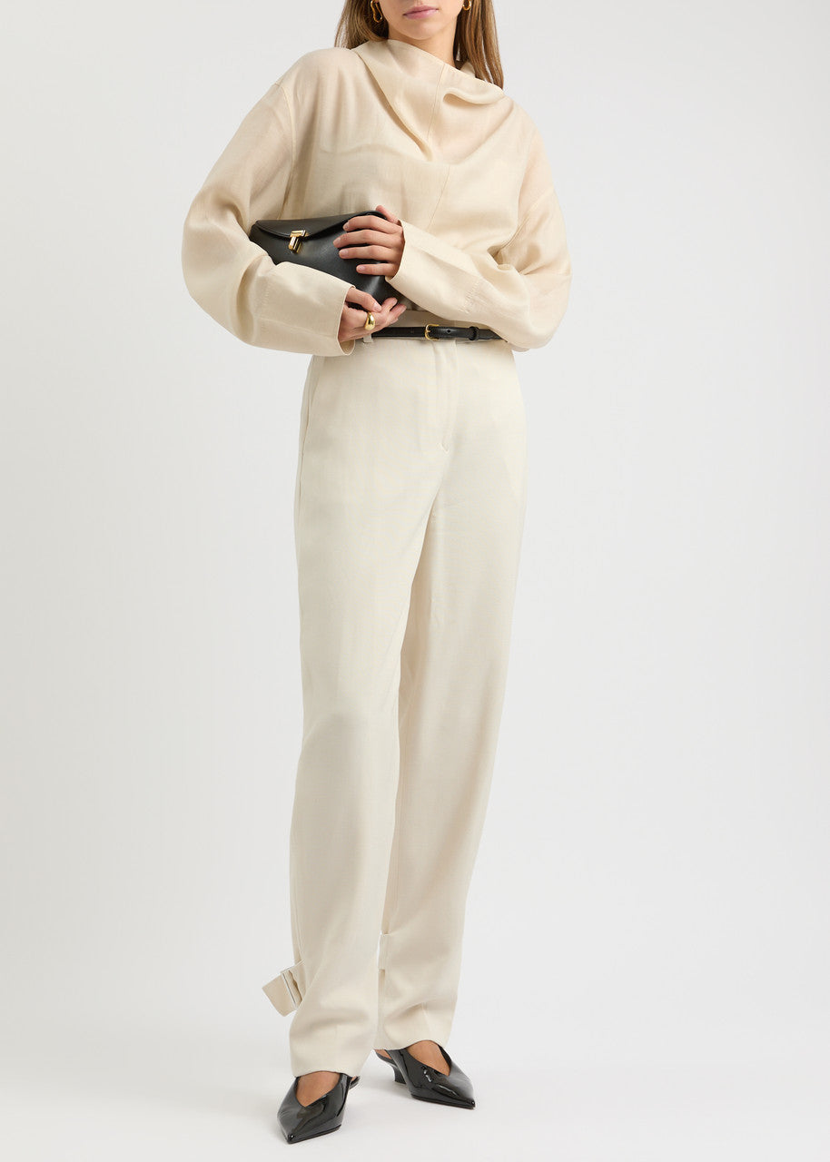 Elevate your wardrobe with this draped woven blouse by Toteme featuring a sophisticated funnel neck and relaxed dropped shoulders for effortless style. The curved hem with a longer back adds a contemporary silhouette, while the detachable cami lining offers versatility and comfort. Perfect for both casual and polished looks, this blouse combines elegance with adaptable wearability.