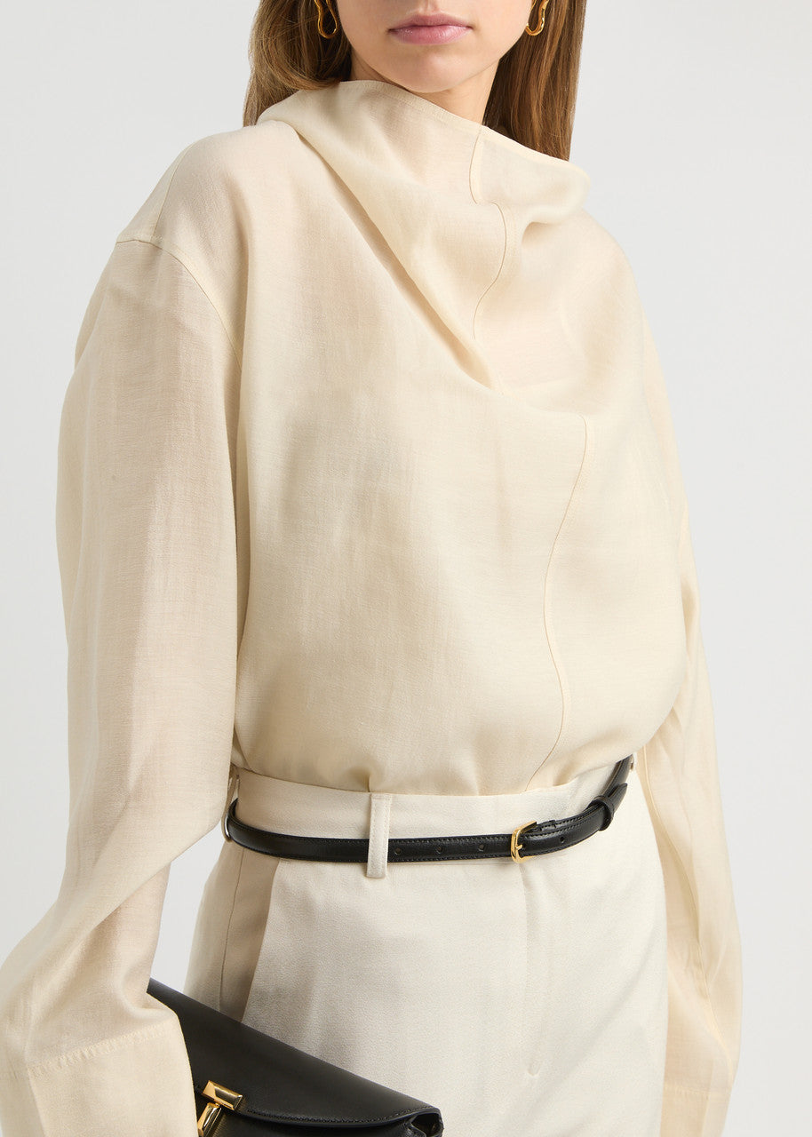 Elevate your wardrobe with this draped woven blouse by Toteme featuring a sophisticated funnel neck and relaxed dropped shoulders for effortless style. The curved hem with a longer back adds a contemporary silhouette, while the detachable cami lining offers versatility and comfort. Perfect for both casual and polished looks, this blouse combines elegance with adaptable wearability.