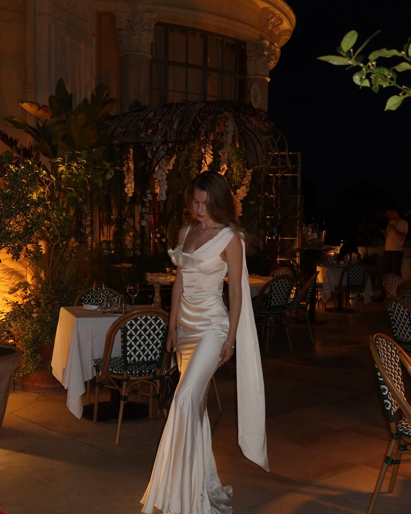 Elevate your elegance with the Celine Corset Gown, a luxurious satin masterpiece designed to flatter every figure. Featuring a corset waist that sculpts your silhouette and graceful draping at the hips, this gown enhances your natural curves. The asymmetric design highlights a delicate rosette on one shoulder and a flowing scarf on the other, adding a unique touch of sophistication. The slightly flared hemline completes this stunning look, perfect for making a memorable entrance at any special occasion.