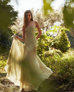 The Sunniva Plisse Strapless Gown showcases a fitted strapless bodice with a gracefully curved dropped waist, leading into a flowing plisse skirt that moves elegantly with every step. Its timeless silhouette emphasizes a refined, feminine shape, perfect for occasions that call for understated sophistication. Pair with statement earrings to elevate the look, capturing the essence of modern elegance.