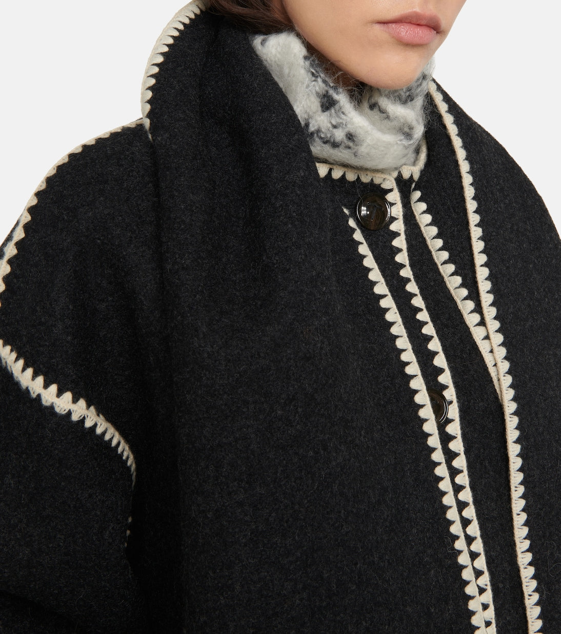 "The epitome of luxury and artistry, the Totême Veste Evelyn jacket exudes sophistication. Expertly crafted with a fringed scarf integrated into the design, this oversized wool blend jacket features dropped shoulders, wide sleeves, and contrast crochet detailing for a truly elevated look."
