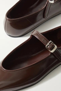 Indulge in sophistication with our Glossed-leather Mary Jane Flats. These timeless flats feature a classic silhouette and sleek almond toes, crafted from dark-brown glossed-leather. Adjustable buckled straps add versatility, making them the perfect choice to complement any outfit - from skinny jeans to tailored pieces.