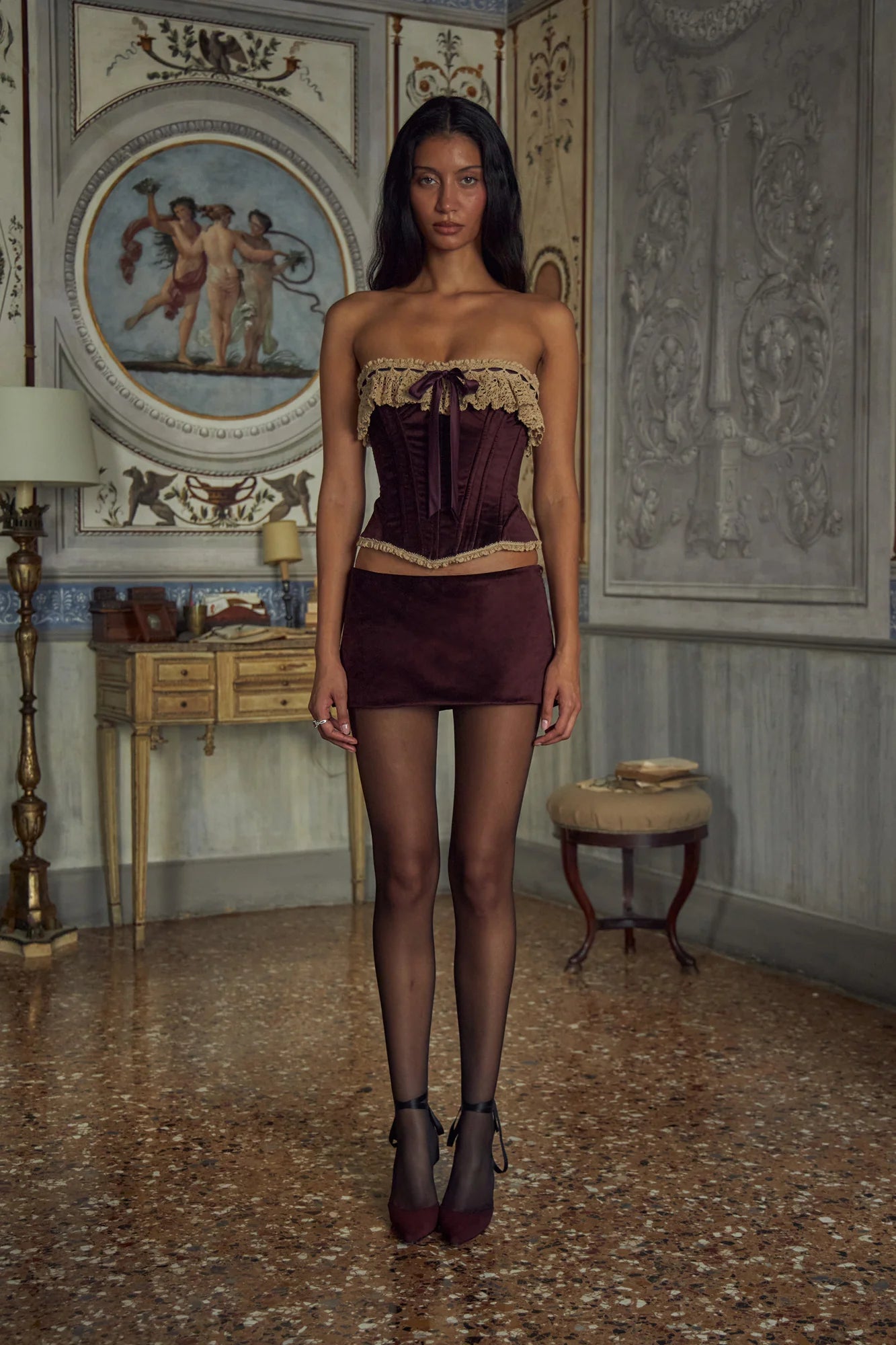 Indulge in opulence with the Victorian Velvet Set. The velvet corset boasts a delicate lace trim and secure silicone gripper while the functional silk ties and bow add a touch of femininity. Boning throughout the bodice accentuates your figure. The matching mini skirt features hidden shorts and an invisible zipper for a seamless silhouette.