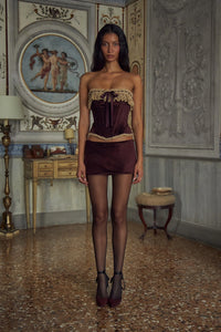 Indulge in opulence with the Victorian Velvet Set. The velvet corset boasts a delicate lace trim and secure silicone gripper while the functional silk ties and bow add a touch of femininity. Boning throughout the bodice accentuates your figure. The matching mini skirt features hidden shorts and an invisible zipper for a seamless silhouette.