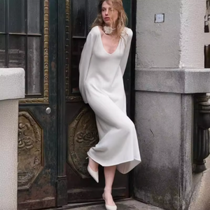 Make a statement with our versatile and timeless V-neck dress in a creamy hue. Perfect for any occasion, from parties to weddings to spring strolls. This dress complements a variety of accessories, allowing you to express your unique style. A must-have for your wardrobe, never going out of style.