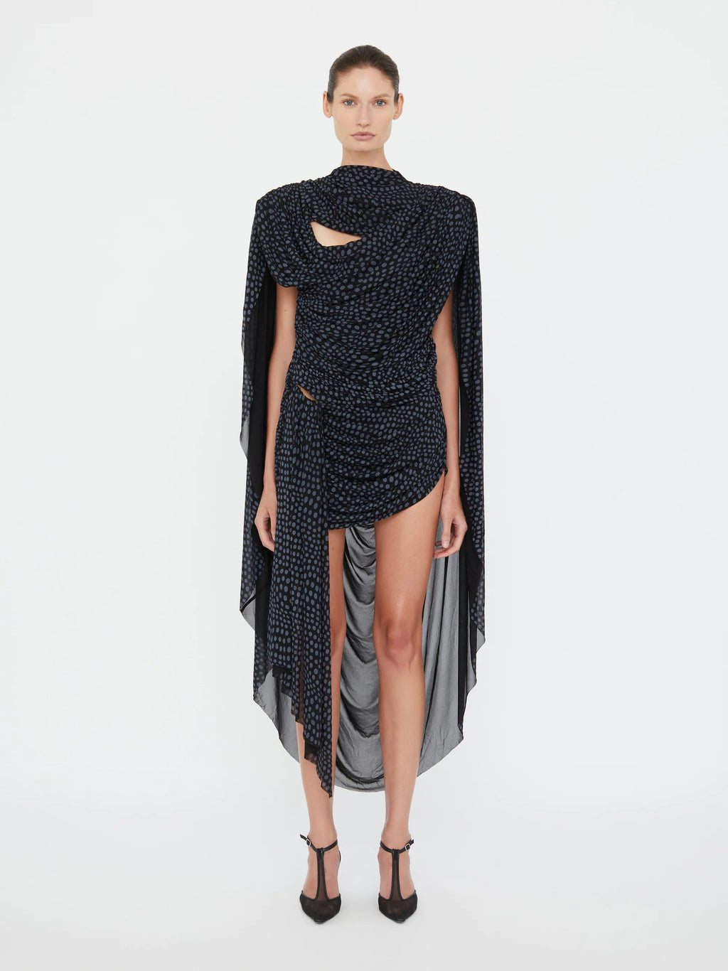 Embrace a nostalgic 90s vibe with the Torrent Draped Mini Dress by Christopher Esber, featuring a striking blue on black warped polka dot pattern inspired by a summer rain shower. The mini silhouette, enriched with gathered and cinched drapes, creates dynamic movement and captivating dimension. Its asymmetric draped skirt and fully lined construction offer effortless style and comfort, making it the perfect choice for standing out with subtle, artistic flair. Pull on this dress to experience a blend of play