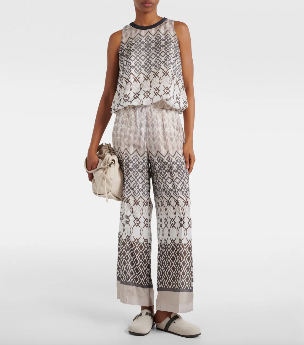 Elevate your wardrobe with the Printed Silk Top by Brunello Cucinelli. This sleeveless top features a playful puffed hem for a flared shape, adding a touch of ethnic whimsy to any outfit. Perfect for those looking for a unique and stylish addition to their wardrobe.