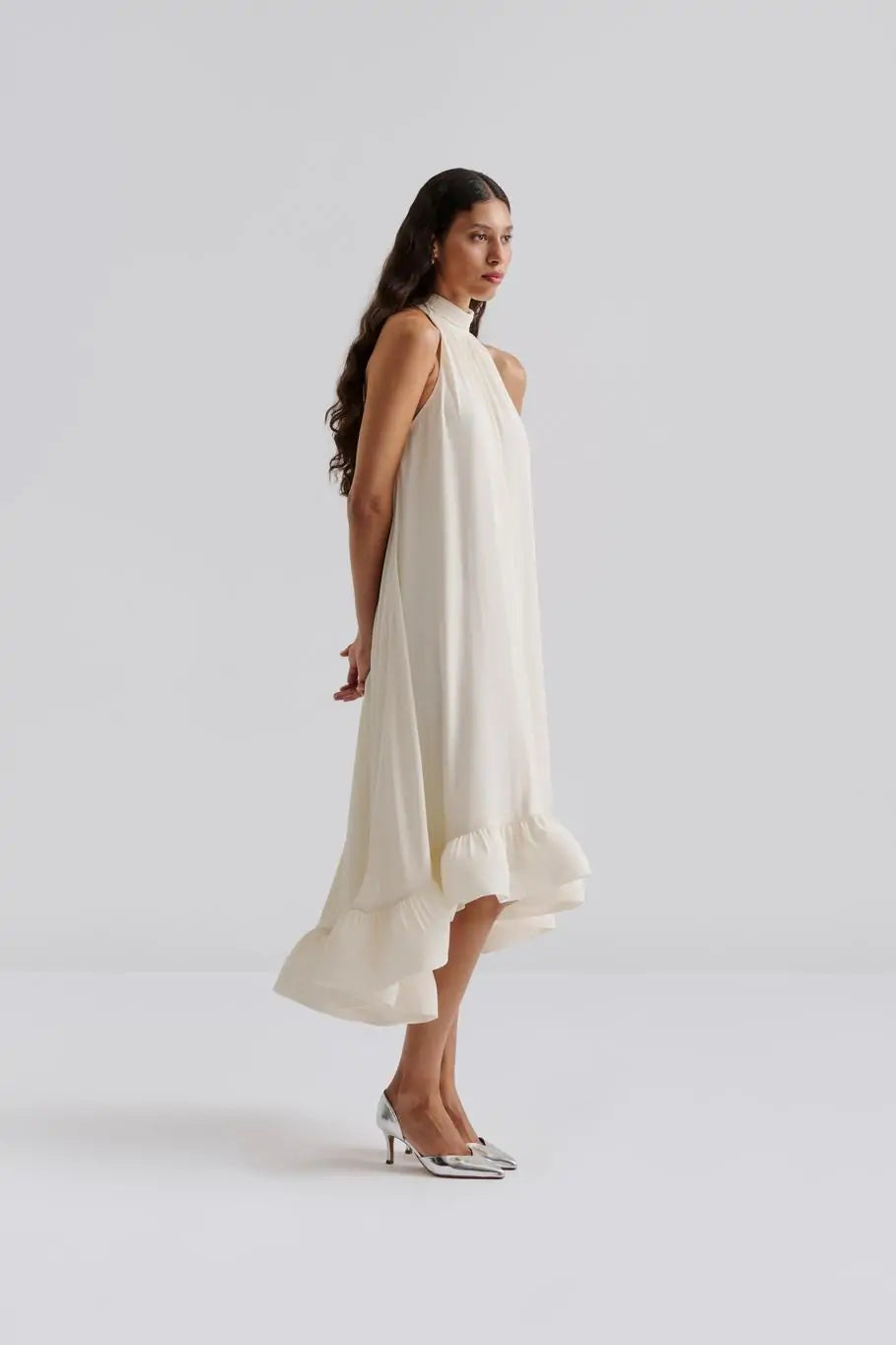 Das Sabrina Halterneck Brautkleid kombiniert zeitlose Eleganz mit romantischem Charme. Das leichte Neckholder-Maxikleid mit offenem Rücken und fließendem, sanft gerüschtem Rock sorgt für eine feminine Silhouette und einen unvergesslichen Auftritt. Der Schleifenverschluss am Nacken setzt Ihre Schultern gekonnt in Szene und macht es zur perfekten Wahl für standesamtliche Trauungen, Sommerhochzeiten oder festliche Anlässe. Fühlen Sie sich mühelos schön und strahlen Sie an Ihrem besonderen Tag.