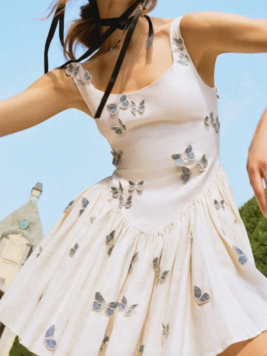 Discover the enchanting Pluma Lymanopoda mini dress, where artistry meets everyday elegance. Delicate butterfly appliqués create the illusion of nature's most graceful creatures landing softly on your skin. Crafted from breathable 100% linen in ivory and blue, this dress features a fitted bodice that transitions into a voluminous gathered skirt at the dropped waist, flattering your silhouette with effortless sophistication. 