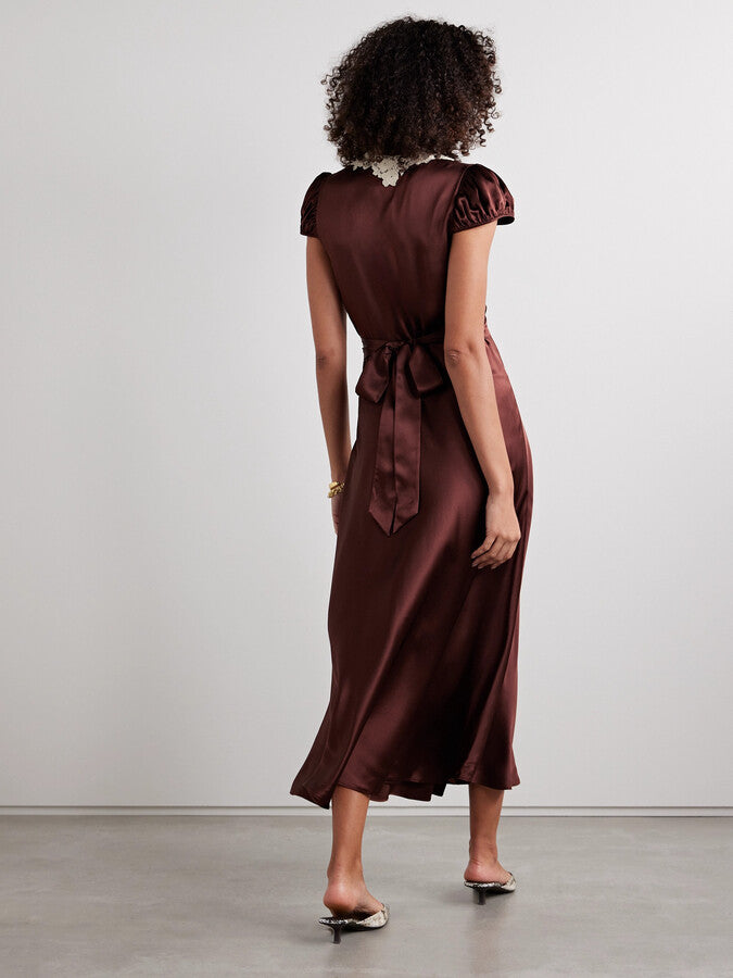 The Silk Lace-Trim Coraline Midi Dress channels the refined elegance of the 1930s with expertly crafted details. Made from lush silk satin, it gracefully drapes the body, enhanced by whimsical gathered cap sleeves. The plunging V-neckline highlights delicate embroidered scallop lace, while the fitted bodice transitions into a flattering bias-cut midi skirt. Adjustable back ties offer a personalized fit, and a subtle embroidered “D” on the bust adds a distinctive signature touch. 