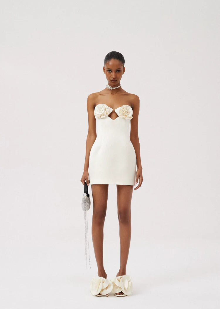 Indulge in this dreamy Flower Bustier Mini Dress by Magda Butrym. The strapless design features bustier cups, connected by a transparent thread, for a seductive touch. Adorned with 3D fabric flowers, this dress is a perfect combination of sophistication and sensuality. Embrace your feminine side in this gorgeous cream-colored dress.