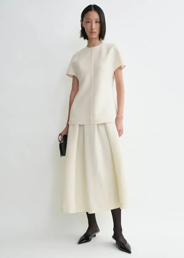 Elevate your wardrobe with this sophisticated TOTEME cap-sleeve top, designed for the modern woman who values refined elegance. The longline silhouette flatters your frame while the distinctive twisted seams add architectural interest to every wear. Crafted from luxurious double-faced cady blended with wool and silk, this piece offers both comfort and durability. The concealed back zipper ensures a seamless, polished look. 