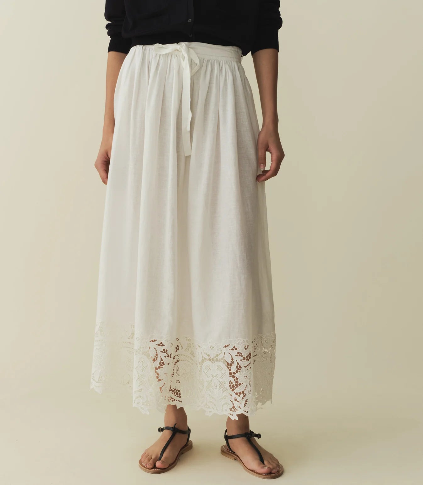 In crisp organic cotton poplin, the antique-inspired DÔEN Heirloom Gloriane Skirt features a high waist with a fixed tie and a full, A-line silhouette. Floral embroidery with hand-done cutwork adorns the hem, which falls to just above the ankle, while an invisible zipper and hook-and-eye closure fastens at the side.