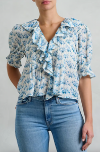 The Henri Top is a stunning blend of romantic Victorian aesthetics and modern sophistication. Made from soft, lightweight organic cotton voile, it features a plunging V-neckline adorned with cascading lace-trimmed ruffles. Delicate clustered pintucks accent the yoke and puffed sleeves, while hidden starburst buttons add a unique touch. Perfect for both casual outings and special occasions, this blouse effortlessly elevates any outfit with its vintage charm and playful elegance.