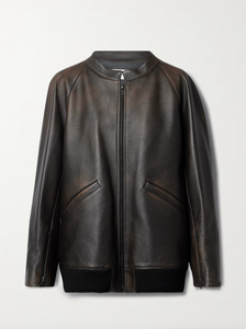 The Row brown oversized motorcycle jacket in distressed calfskin leather with stand collar, raglan sleeves, side welt pockets, and ribbed hem. Finished with silver-toned front and interior cuff zippers. This jacket comes fully lined in silk Habotai.