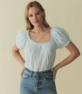 Rendered in 100% organic cotton voile, the Frederica Top features a breezy silhouette, a round neckline, and short puffed sleeves adorned with scalloped lace. Alternating pintuck clusters, lace, and delicate floral embroidery decorate the front. Leave it loose, or tuck it into your favorite pair of high-waisted jeans.