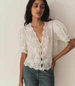 Load image into Gallery viewer, Crafted from lightweight, crisp ramie, the Idella Top from Doen features a plunging V-neckline, short puffed sleeves, and intricate embroidered lace details. Mother-of-pearl buttons adorn the front, while lace insets add delicate touches. This antique-inspired top is perfect for a breezy, feminine look.
