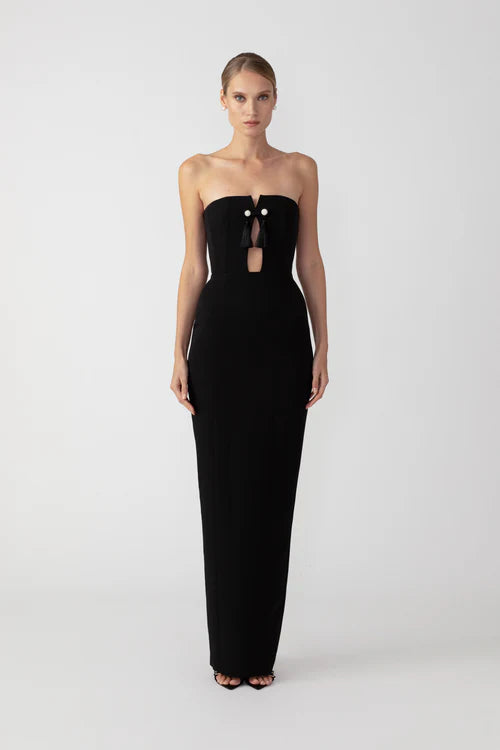 Imani is a modern black-tie strapless gown featuring a classic figure-sculpting shape. The bust is uniquely structured with internal boning featuring a playful keyhole front cut-out and button tassles. Made of premium crepe for a flattering and comfortably snug fit around the hips.