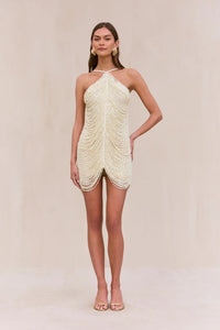 Indulge in the luxurious and exclusive Domina Dress by Cult Gaia. This exquisite halter dress boasts a layered and draped faux pearl fringe that gracefully moves with you. The plunging open back and flattering v-cut silhouette make this mini dress a must-have for any elegant occasion. Elevate your style with this captivating piece.