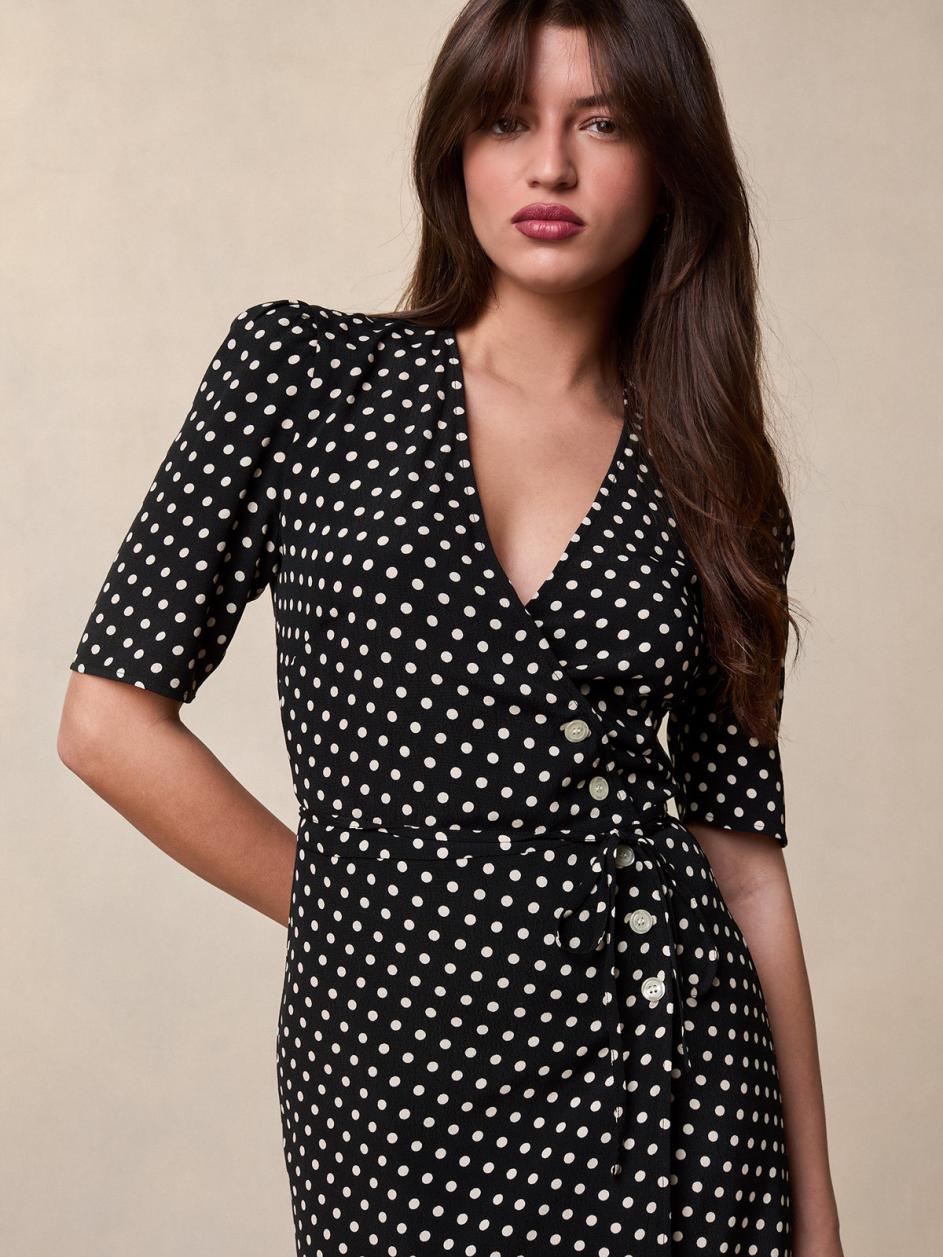 Feel effortlessly chic and sophisticated in our Carmen Midi Dress. The black and white weight print adds a touch of elegance while the V neckline and five button and tie fastening on the front create a flattering silhouette. The lined skirt ensures comfort and poise. Perfect for any occasion.