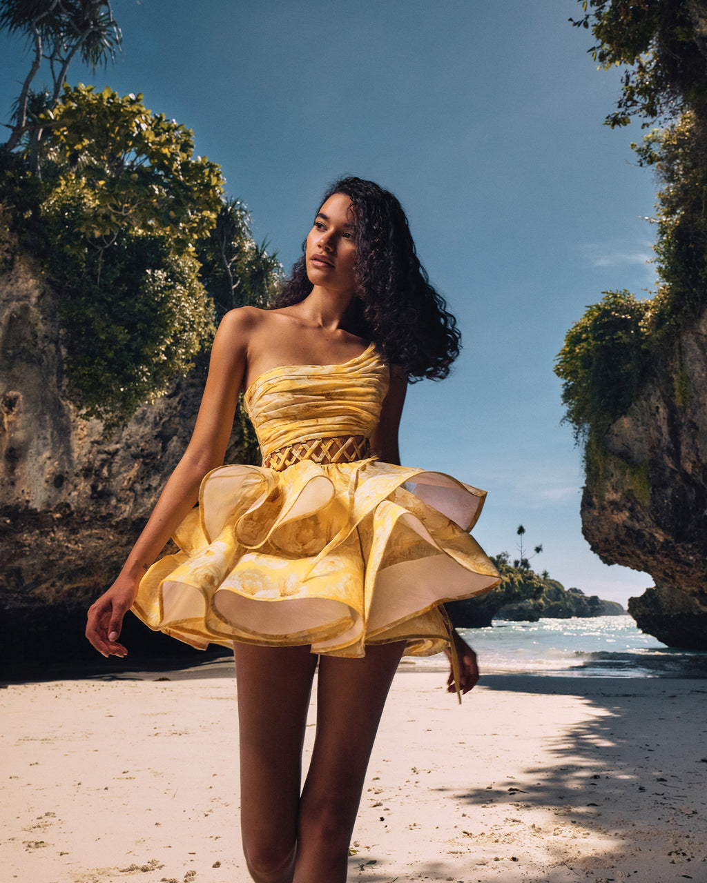The Iris Mini Dress by YVON combines premium linen silk fabric with a delicate yellow floral print inspired by fairy forest blossoms. Its handcrafted asymmetrical bodice enhances feminine contours with refined subtlety, while the adjustable waist lacing ensures a perfectly sculpted silhouette. This dress expertly merges romantic elements with sophisticated craftsmanship, making it an exceptional choice for those seeking elegance with distinctive style.