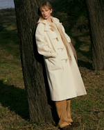 Load image into Gallery viewer, Upgrade your winter wardrobe with the Chelsea Duffle Coat. Made from premium boucle fabric, this coat features four toggle-and-cord fastening closures for a stylish touch. Stay cozy and warm with the full interior lining and functional hood. Thoughtfully placed outer pockets and an oversized fit make this coat both fashionable and functional.
