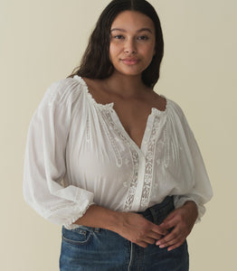 Crafted from a 100% organic cotton voile, the Abigail Top features a breezy silhouette, a round neckline, and buttons running down the center front. Billowy sleeves trimmed with scalloped lace hit just above the wrist, while alternating pintuck clusters, lace, and delicate floral embroidery decorate the front. Leave it loose, or tuck it into your favorite pair of high-waisted jeans.