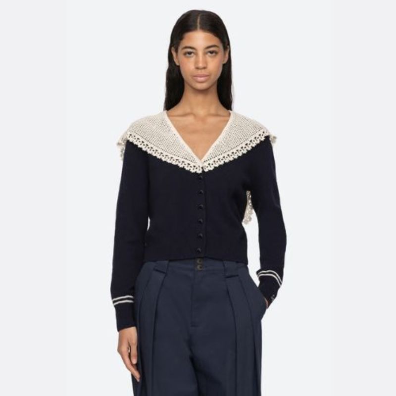 The Marie Cardigan by SEA combines effortless elegance with luxurious comfort. This sophisticated knit features a flattering v-neckline, intricate crochet capelet detail, and an embroidered 'Sea' logo on the cuff. Crafted from premium extra fine merino wool with cotton combo accents, it delivers a soft, breathable wear that moves with you. The relaxed button-front silhouette strikes the perfect balance between polished and comfortable, making it an essential layering piece for any wardrobe. 
