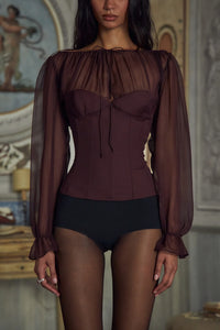 Indulge in luxury with the Chianti Silk-chiffon Blouse. The adjustable neckline and delicate silk ties exude elegance, while the boning and elastic ensure a perfect fit. With smocking and lace-up details at the back, this bustier blouse will elevate any outfit. Available with a side closure for easy wear.