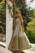 Load image into Gallery viewer, Indulge in luxury with the Aurora Gown, a soft pistachio dress made of satin fabric that exudes elegance and femininity. The open shoulders and sophisticated sleeves highlight your features while the crystal decorated hem adds a touch of brilliance. Hand-cut rose petals create a voluminous and unique look, perfect for any special occasion.
