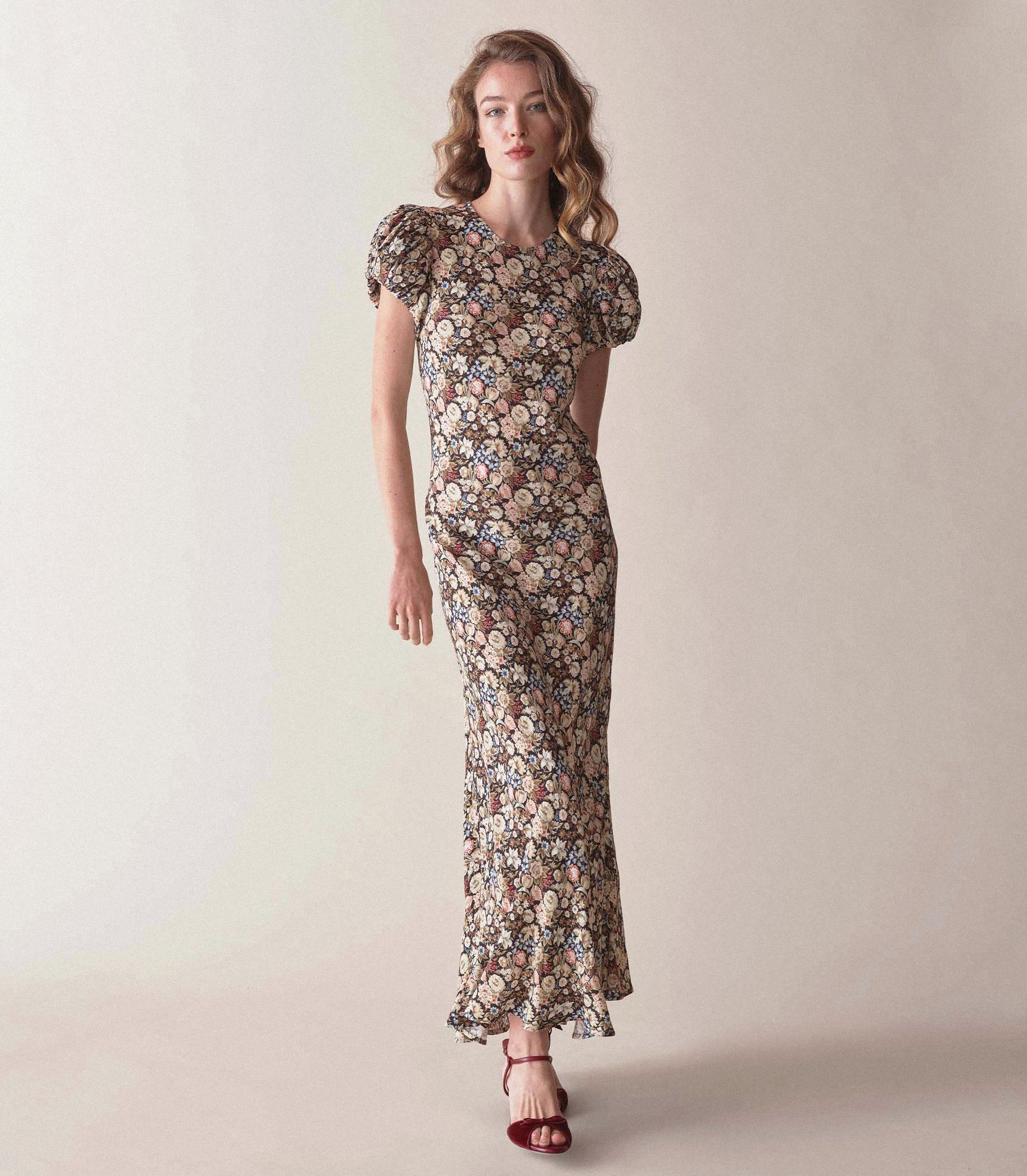 Introducing the Merla Maxi Dress, the perfect addition to your summer wardrobe. Made with viscose, this dress features a stunning floral print, short puff sleeves, and a slim fit for a flattering look. With its round neckline, it's both comfortable and stylish. Elevate your summer style with this must-have dress.